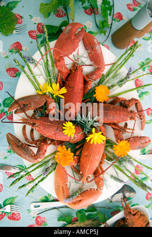 an aerial view of a lavish seafood dish of langoustines, spider crabs and lobsters, decorated with assorted flowers on a table Stock Photo