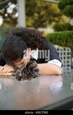 Maid Resting Head On Table Outdoors Stock Photo