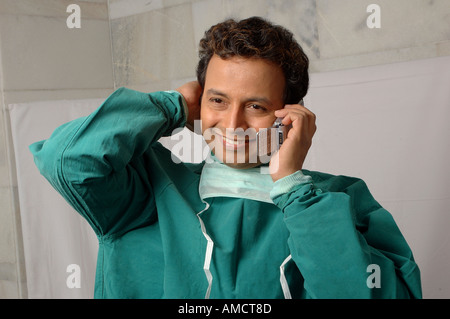 Doctor surgeon smiling talking on mobile phone , MR#637 Stock Photo