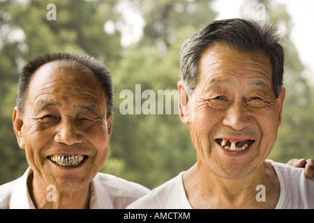 Portrait of two men with bad teeth smiling outdoors Stock Photo