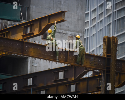 Two male construction workers outdoors on girders Stock Photo