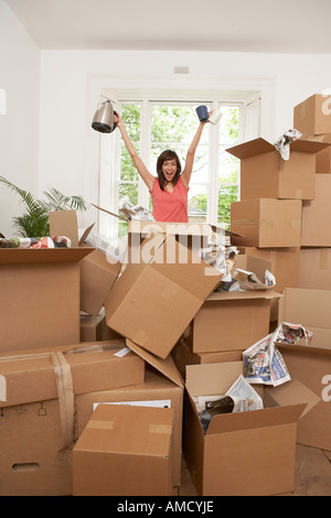 Woman Finding Coffee Pot and Mugs in Boxes Stock Photo
