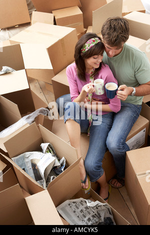 Couple Having Coffee amongst Boxes Stock Photo