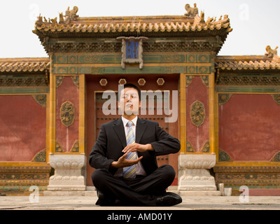 Businessman sitting cross legged outdoors with laptop Stock Photo - Alamy