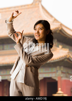 Businesswoman doing tai chi outdoors smiling Stock Photo