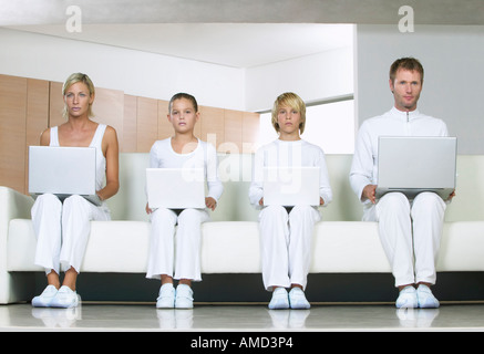 Portrait of Family Sitting on Sofa, Using Laptop Computers