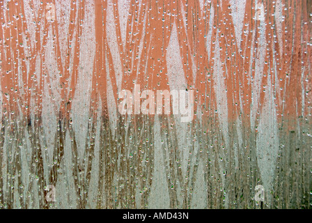 view looking out of a window focused on rain drops and condensation with a dominant green and red background Stock Photo