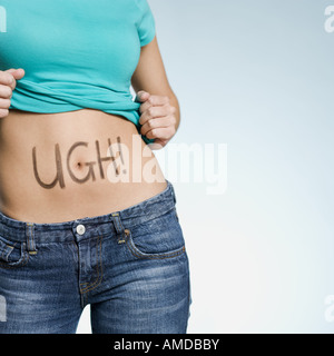 Female Abdomen with UGH! written on it Stock Photo