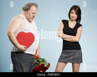 Disheveled man with heart box and red roses with disinterested woman Stock Photo