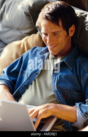 Man Sitting on Sofa Using Laptop Computer Stock Photo