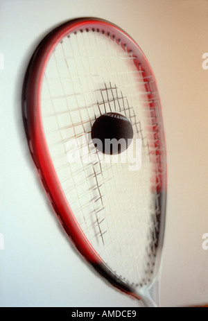 Squash racket striking a ball Stock Photo