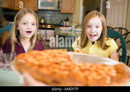 View of two girls looking at pizza. Stock Photo
