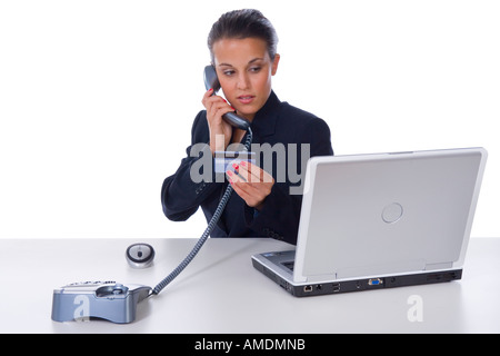 Office worker reading credit card Stock Photo