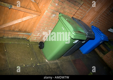 Wheelie bins lined up against a garage Stock Photo