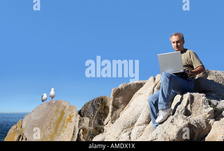 Man working outdoors on his laptop Stock Photo