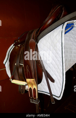 Saddle on a rack in a tack room horseback riding equipment Stock Photo