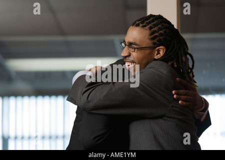 Two Business man embracing in office. Stock Photo