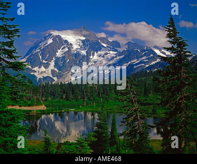 Mount Shuksan reflected in Picture Lake in the Cascade Mountains of Northern Washington dressed in summer greenery Stock Photo