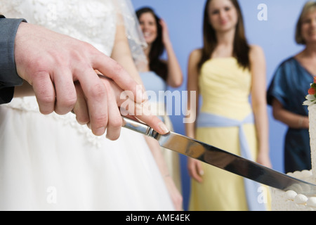 Midsection of a couple cutting cake. Stock Photo