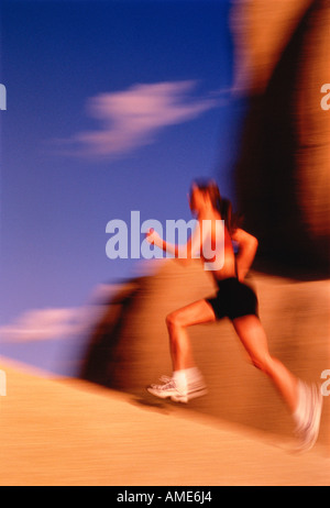 Blurred View of Woman Running On Rock Stock Photo