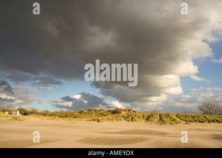Huge cloud formation over sunny dunescape Stock Photo