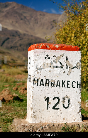 Milestone for Marrakech along the road from Ourazazate in the High Atlas Mountains of Morocco. Stock Photo