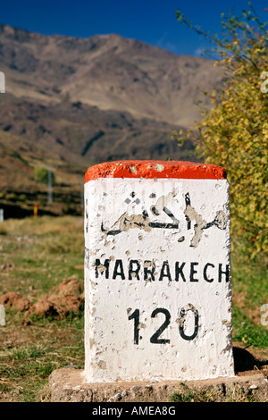 Milestone for Marrakech along the road from Ourazazate in the High Atlas Mountains of Morocco. Stock Photo