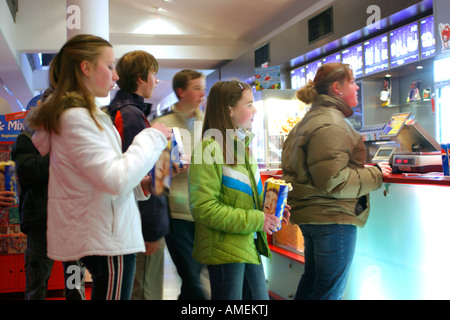 teenagers queuing up to get sweets at a cinema before the film starts Stock Photo