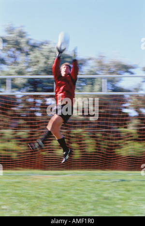 Soccer Goalie Jumping to Catch Ball, Ontario, Canada Stock Photo