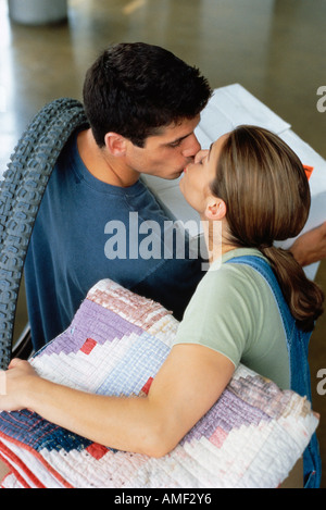 Couple Kissing while Moving into New Home Stock Photo