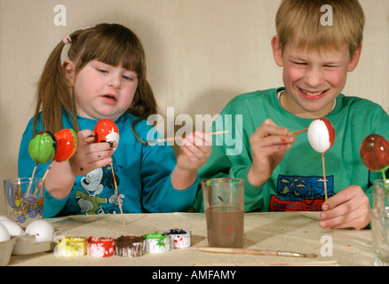 portrait of a young boy and a young girl colouring Easter eggs Stock Photo
