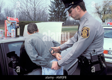 High school teenagers arrested by police for drinking alcohol while driving a car Stock Photo