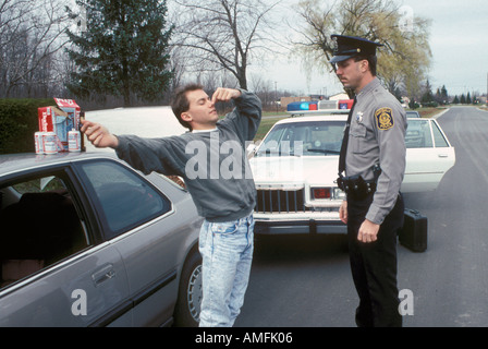 High school teenagers arrested by police for drinking alcohol while driving a car Stock Photo