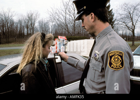 High school teenagers arrested by police for drinking alcohol while driving a car Stock Photo