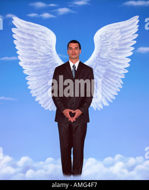 A portrait of young man in a business suit and wings against blue sky Stock Photo