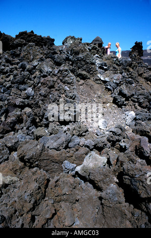 Tourists walk over the still warm lava flow from a recent eruption of Mount Etna volcano in Sicily ,Italy Stock Photo
