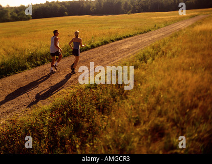 Couple Running on Dirt Road, Maine, USA Stock Photo