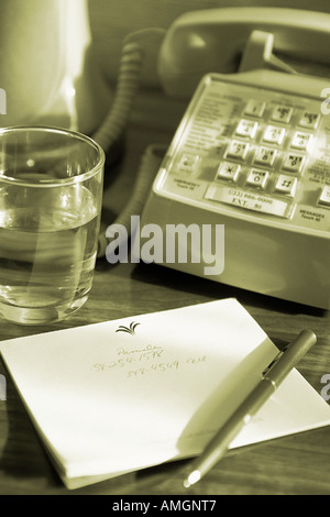 Notepad, Glass of Water and Hotel Room Phone