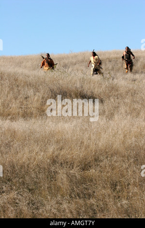 Three Native American Indian men hunting with a bow and arrow in ...