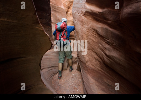 Hiker in Peek a Boo slot canyon near Escalante in Grand Staircase National Monument Utah USA Stock Photo