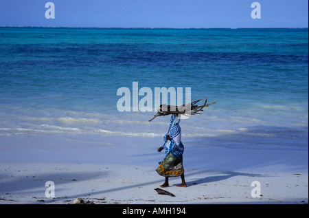 Paje Beach native woman carrying firewood on Zanzibar island, Tanzania, East Africa Stock Photo