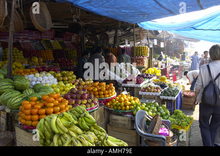 A European tourist walks past a fruit stall at INA market, New Delhi, India. Stock Photo
