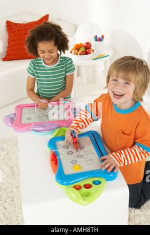 Two children draw on magnetic art easels Stock Photo
