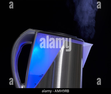 MODERN STAINLESS STEEL KETTLE WITH BLUE LIGHT INSIDE AND STEAM FLOWING FROM SPOUT Stock Photo