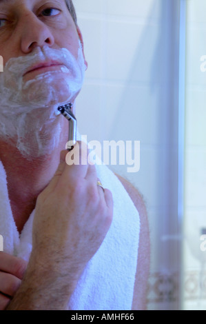 Man shaving with razor using foam in bathroom in the morning Stock ...