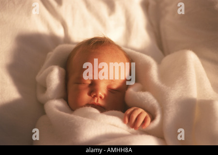 Baby 3 months old wrapped in favorite white blanket Stock Photo