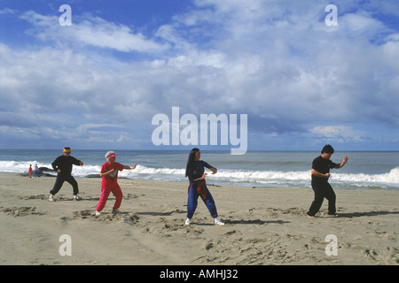 Four people of ethnic mix doing Tai Chi on California beach Stock Photo