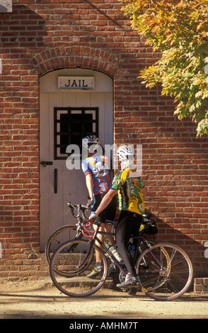Couple on bicycles at old city jail in Jacksonville Oregon a National Historic Landmark Stock Photo