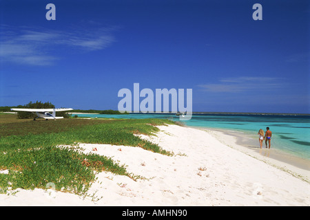 Couple and private plane on Caribbean beach on Tortuga Island in Los Roques archipelago off Venezuela Stock Photo