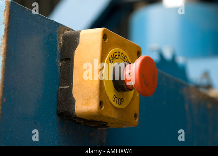 Red emergency stop button on industrial machine in factory England UK Stock Photo
